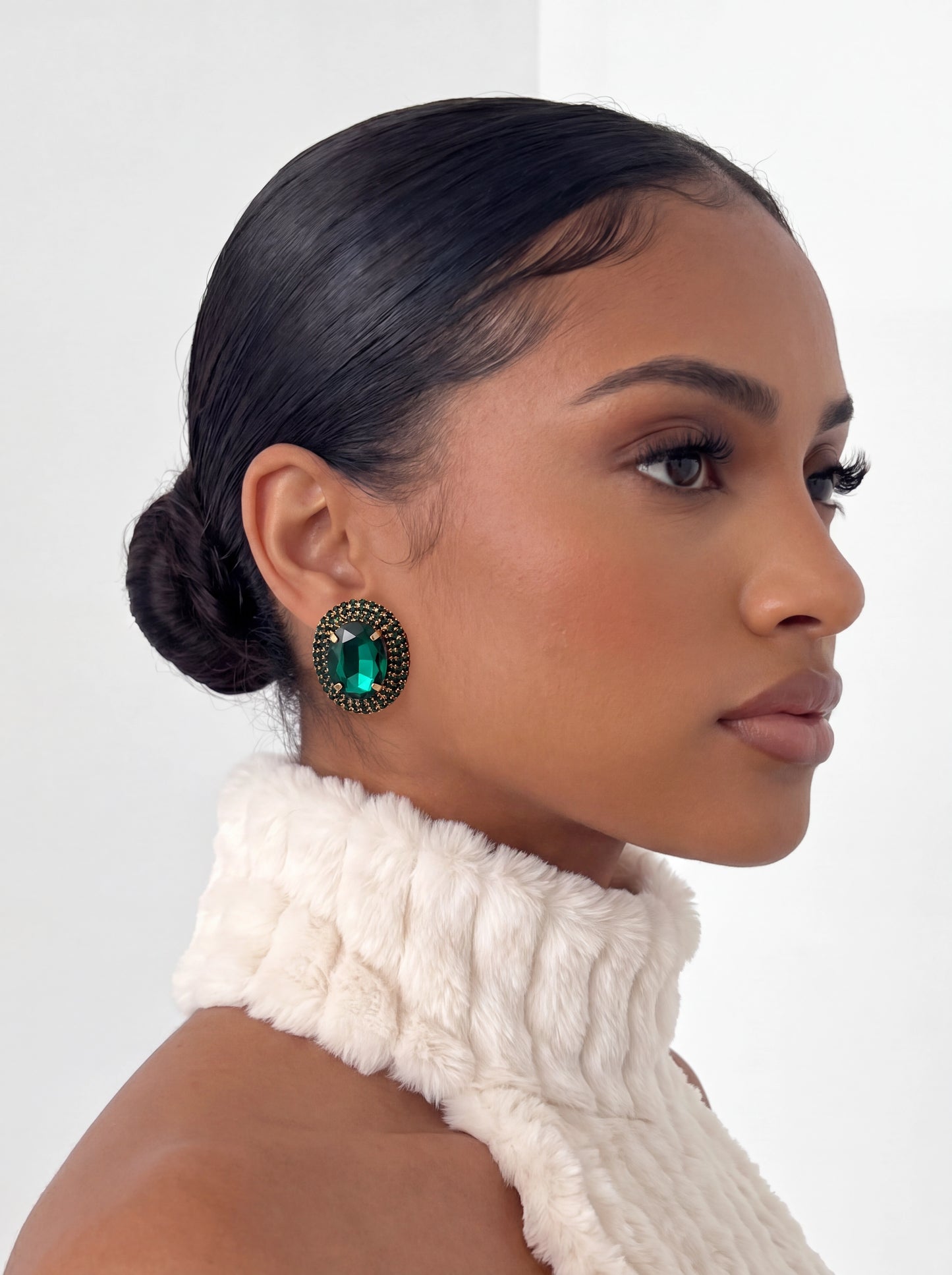 The Emerald Heirloom Earrings feature a brilliant emerald-green faceted stone framed by shimmering crystal accents, creating a timeless statement that elevates any look.