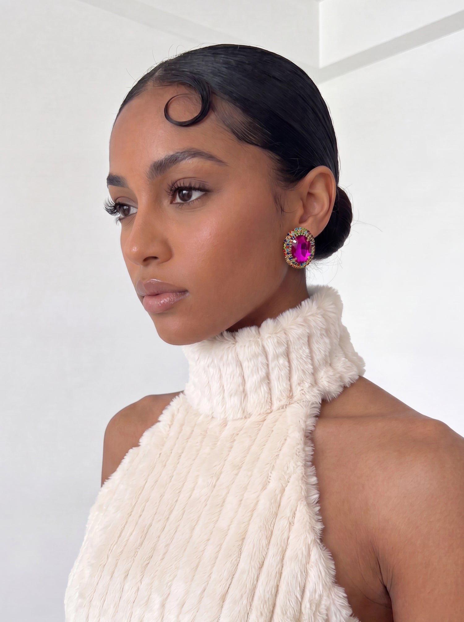 Featuring a vibrant fuchsia gemstone framed by multicolored crystal accents, these statement earrings bring bold color and playful luxury to any look.