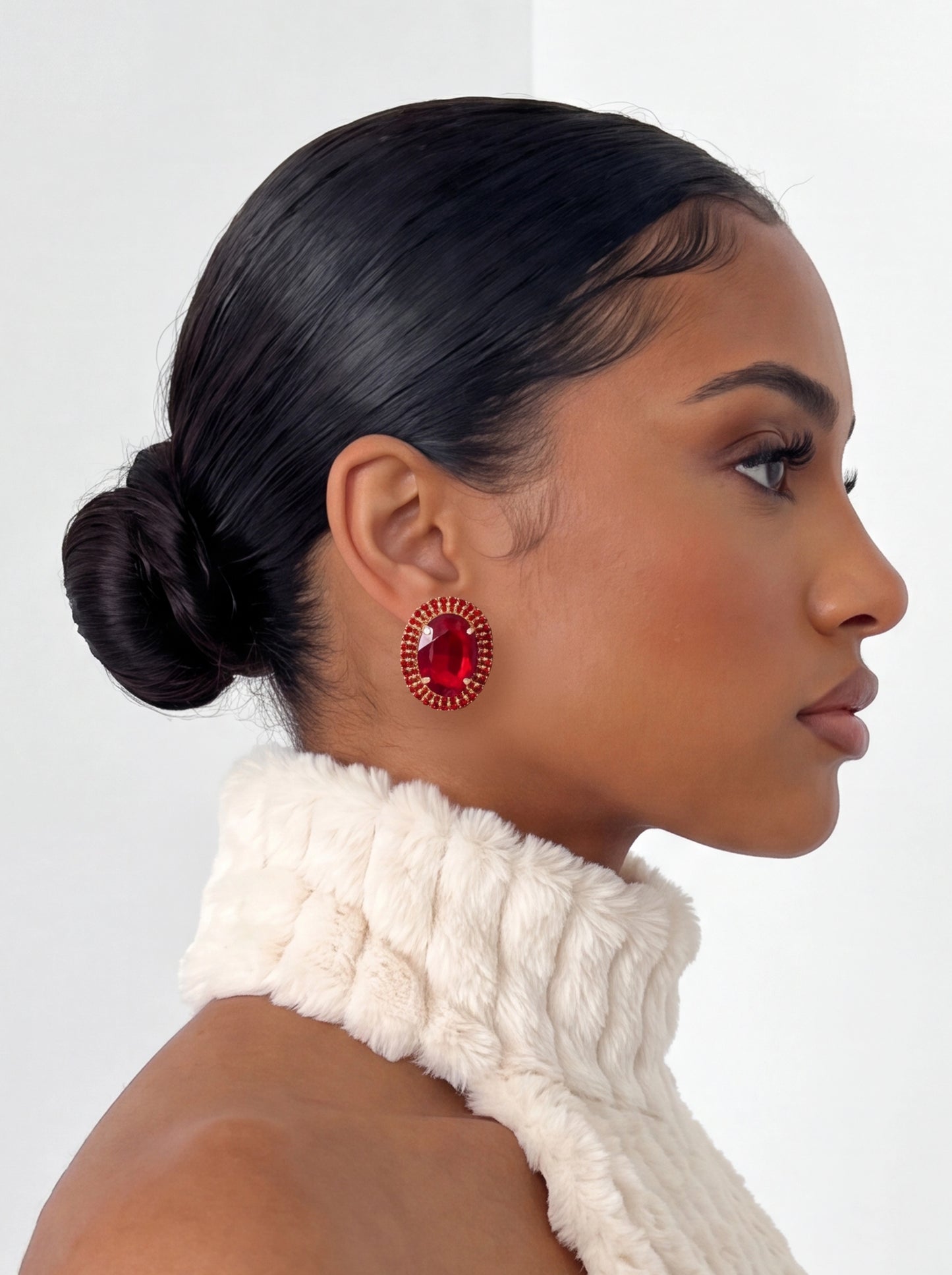 Make a statement with radiant ruby-red crystal studs featuring a faceted center stone surrounded by shimmering pavé accents for a timeless, glamorous finish.