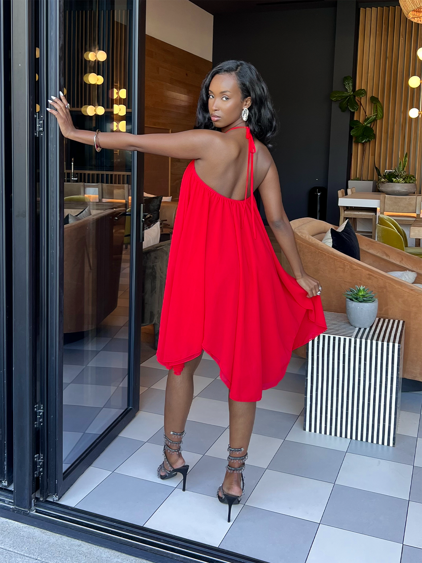 Woman in a red dress standing in a modern interior setting